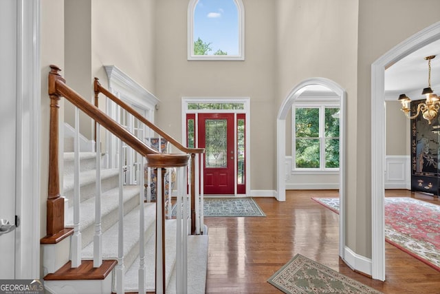4225 Dunham Park, Flowery Branch, GA 30542 - entrance foyer featuring healthy amount of natural light, a towering ceiling, a chandelier, wood finished floors, and stairway