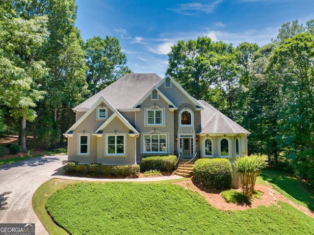 4225 Dunham Park, Flowery Branch, GA 30542 - view of front of house featuring a front yard, driveway, and stucco siding