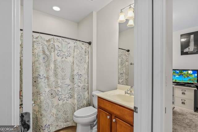 bathroom featuring toilet, vanity, and a shower with curtain