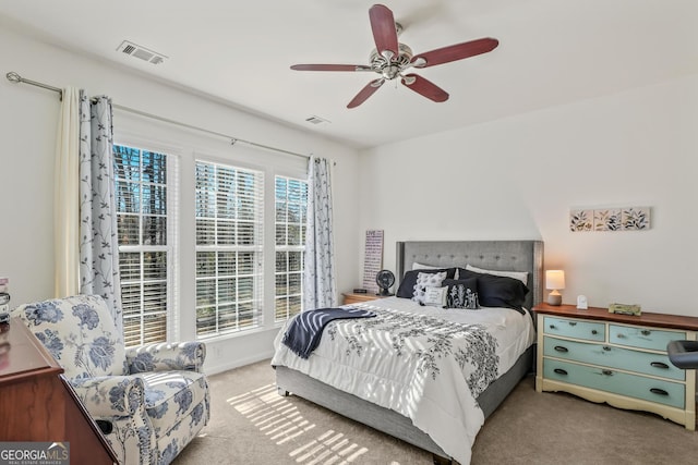 carpeted bedroom with ceiling fan and multiple windows