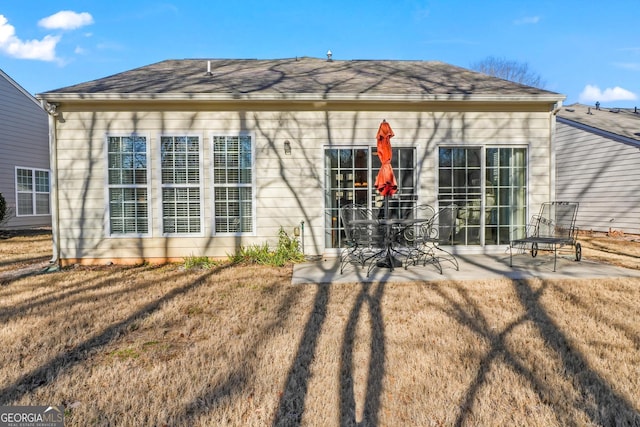 rear view of house with a yard and a patio