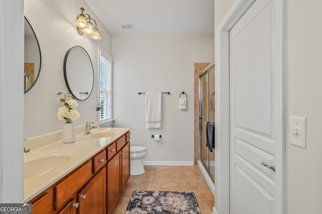 bathroom featuring toilet, tile patterned flooring, walk in shower, and vanity