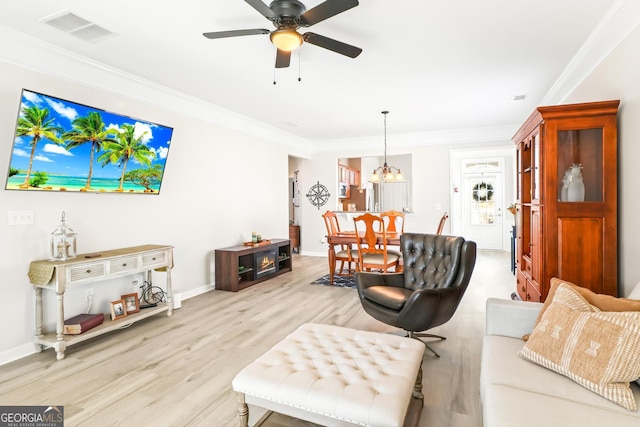 living room with ceiling fan with notable chandelier, crown molding, and light wood-type flooring