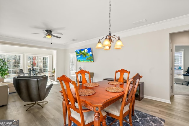 dining space featuring ceiling fan with notable chandelier, crown molding, and light hardwood / wood-style flooring