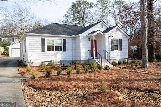 view of front of house with a garage and an outbuilding