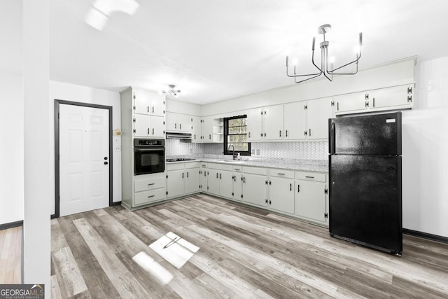 kitchen with tasteful backsplash, light wood-type flooring, black appliances, white cabinets, and sink