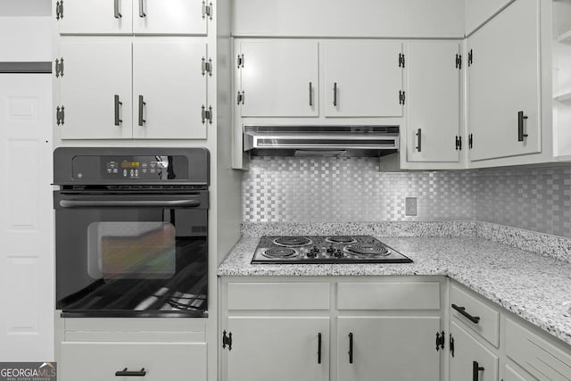 kitchen with decorative backsplash, light stone counters, white cabinets, and black appliances