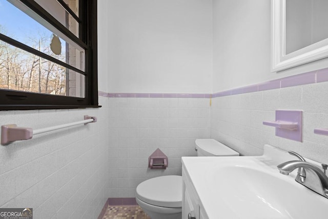 bathroom featuring tile walls, toilet, and vanity