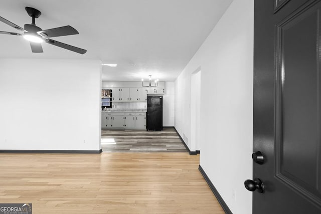 corridor with light hardwood / wood-style floors and a chandelier