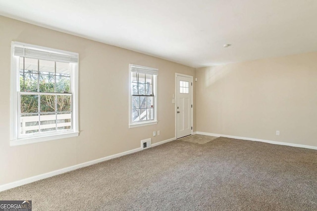 foyer entrance featuring carpet floors and a healthy amount of sunlight