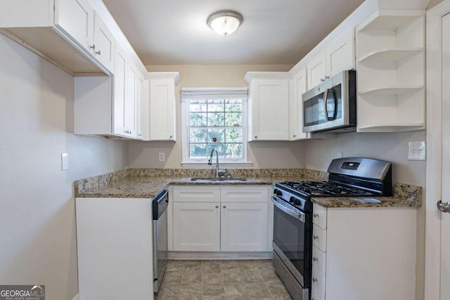 kitchen featuring appliances with stainless steel finishes, white cabinetry, and sink