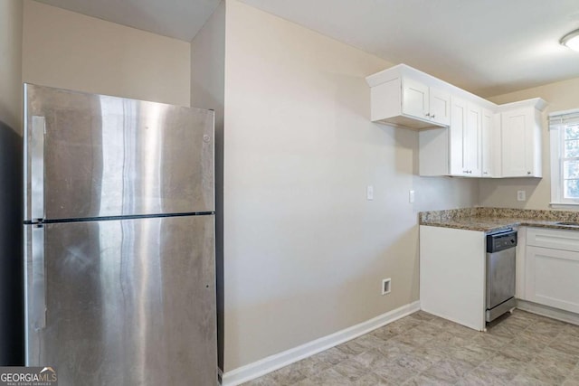 kitchen featuring appliances with stainless steel finishes, white cabinetry, and light stone countertops