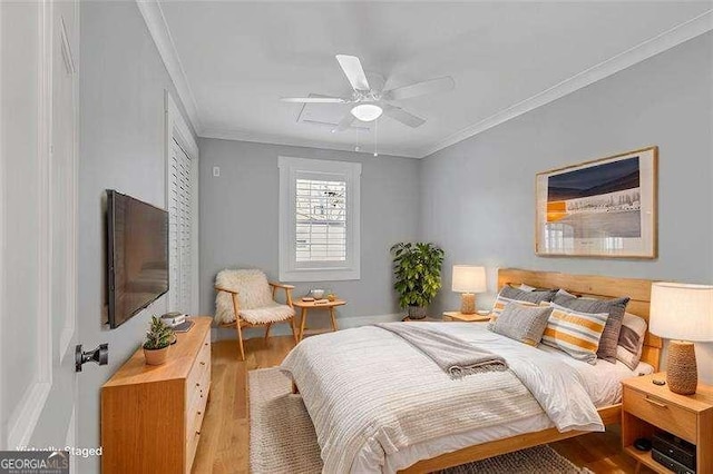 bedroom featuring ceiling fan, hardwood / wood-style floors, and crown molding