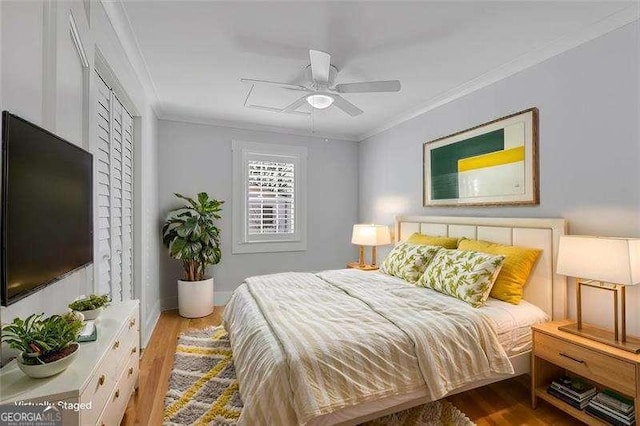 bedroom with ceiling fan, hardwood / wood-style floors, a closet, and crown molding