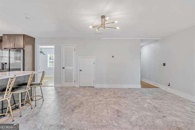 kitchen featuring a breakfast bar area, stainless steel fridge, and a notable chandelier