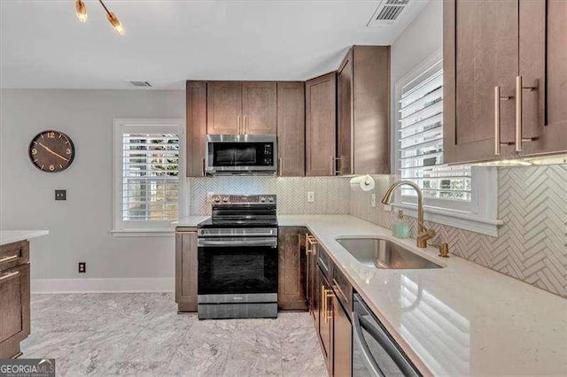 kitchen featuring tasteful backsplash, a healthy amount of sunlight, sink, and stainless steel appliances