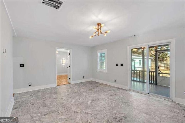 spare room featuring a wealth of natural light and a chandelier