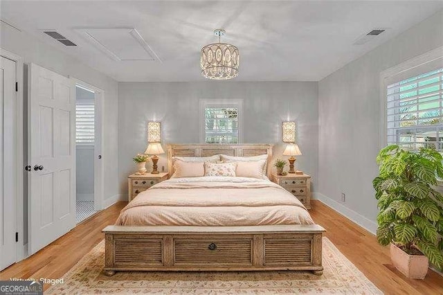 bedroom featuring light wood-type flooring and a notable chandelier