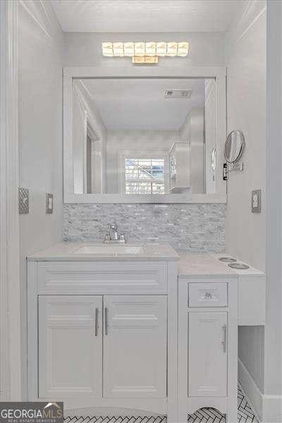 bathroom featuring tasteful backsplash and vanity