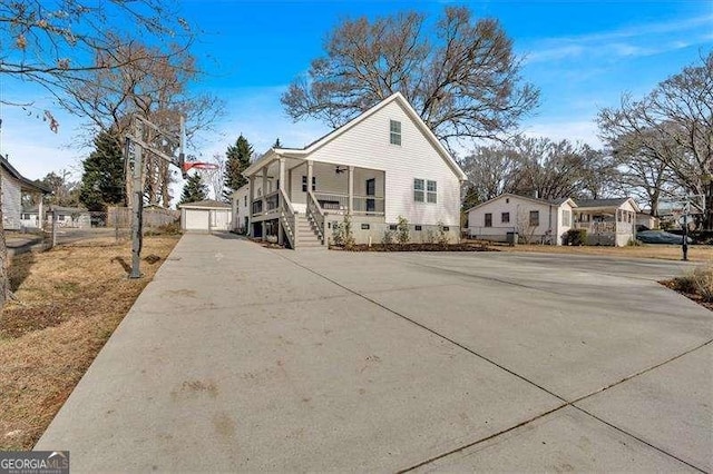 view of front of property featuring covered porch, a garage, and an outbuilding