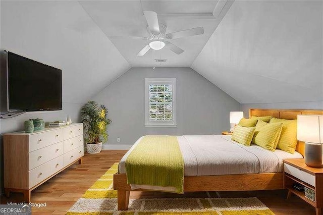 bedroom with light wood-type flooring, ceiling fan, and vaulted ceiling