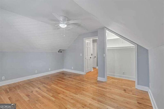 additional living space featuring ceiling fan, light hardwood / wood-style flooring, and vaulted ceiling