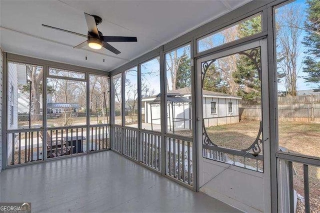 unfurnished sunroom featuring ceiling fan