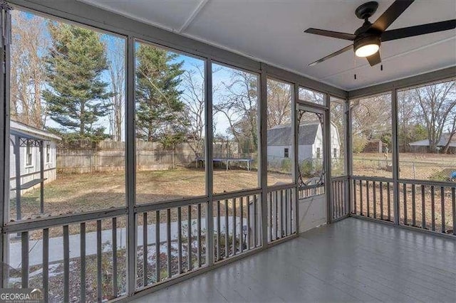 unfurnished sunroom with ceiling fan