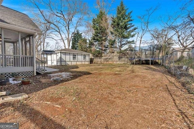 view of yard featuring a sunroom and a trampoline