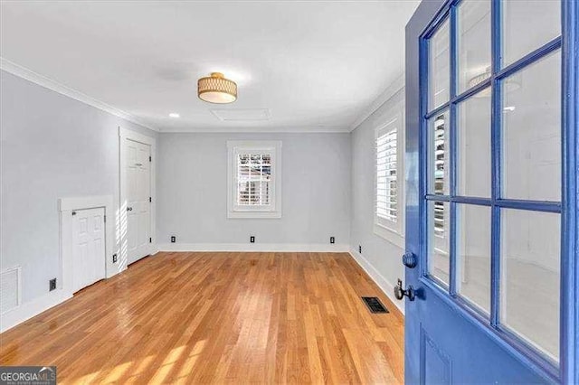 spare room featuring light hardwood / wood-style floors and ornamental molding