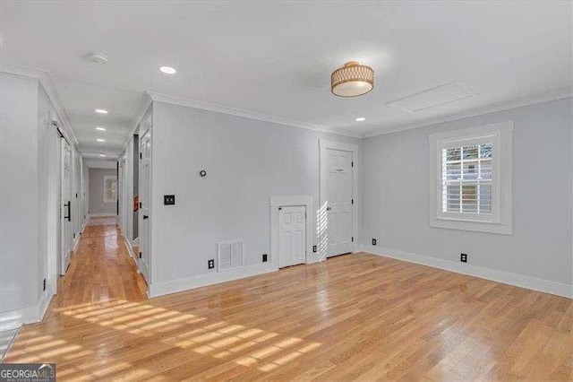 spare room with light wood-type flooring and crown molding