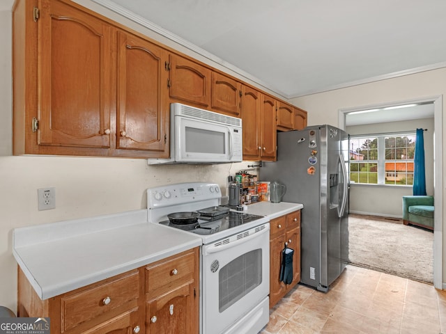 kitchen with white appliances, crown molding, and light carpet