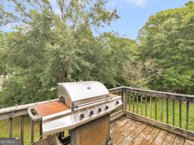 deck featuring a lawn and area for grilling