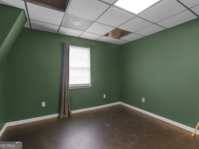 unfurnished room featuring a paneled ceiling and concrete flooring