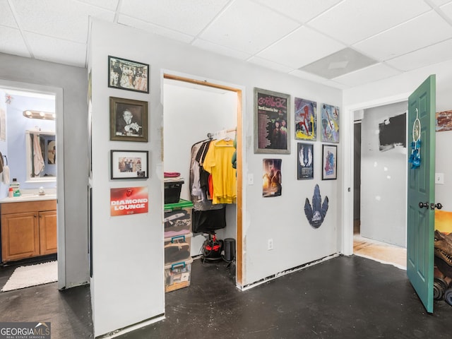 hall with a paneled ceiling and sink