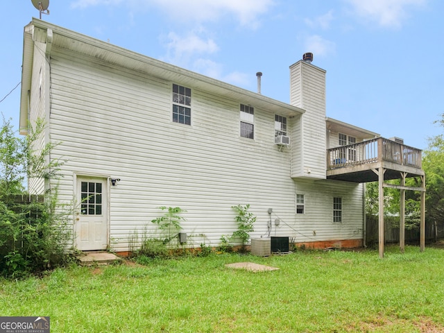 rear view of house with central AC unit, a wooden deck, cooling unit, and a lawn