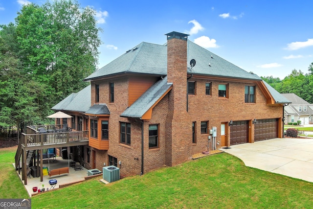 rear view of house featuring a wooden deck, a lawn, central AC unit, a patio, and a garage