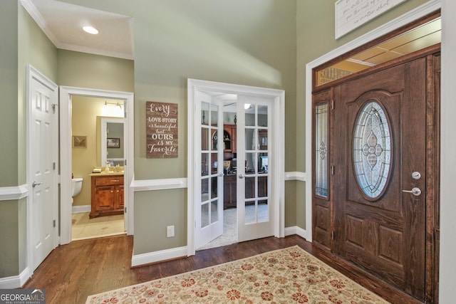 entrance foyer with french doors, dark hardwood / wood-style flooring, and crown molding