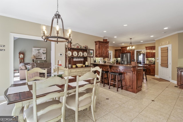 tiled dining area featuring a chandelier and crown molding