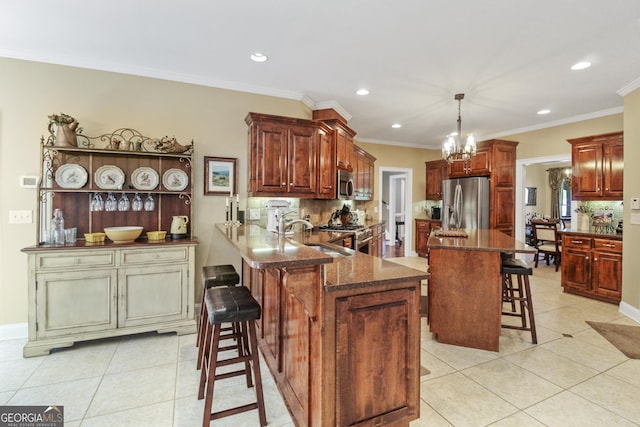 kitchen featuring pendant lighting, appliances with stainless steel finishes, sink, a kitchen breakfast bar, and kitchen peninsula