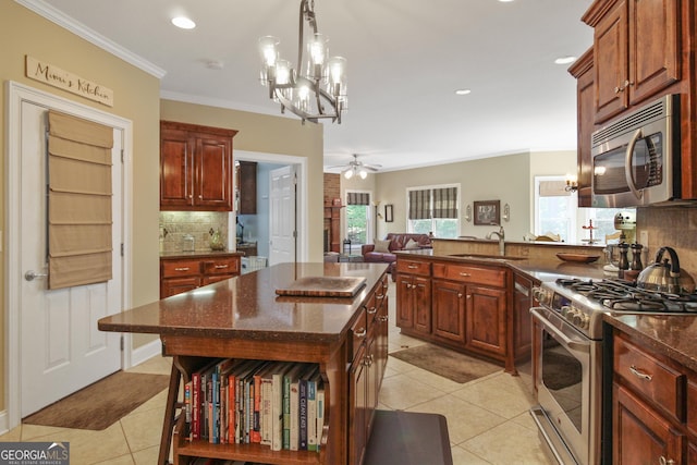 kitchen with ceiling fan with notable chandelier, a center island, stainless steel appliances, backsplash, and light tile patterned floors