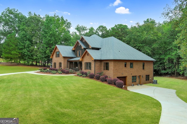 view of front of home with a garage, a front lawn, and central AC unit