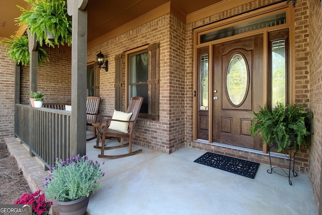 view of exterior entry featuring covered porch