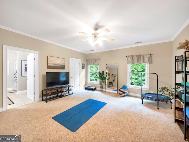 workout area with ceiling fan, crown molding, and light colored carpet