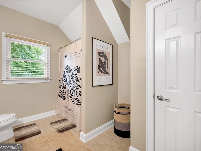 bathroom with vaulted ceiling, a shower with curtain, tile patterned floors, and toilet