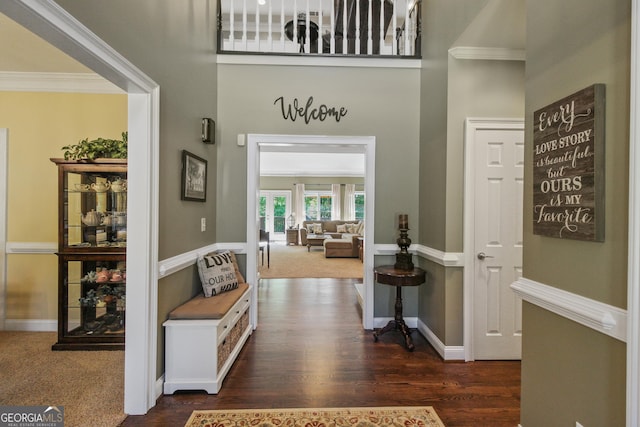 foyer entrance with dark hardwood / wood-style flooring and crown molding