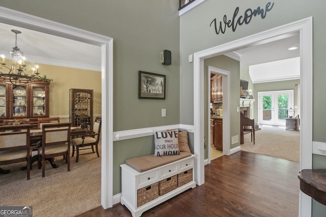 corridor with dark hardwood / wood-style flooring, crown molding, and a chandelier