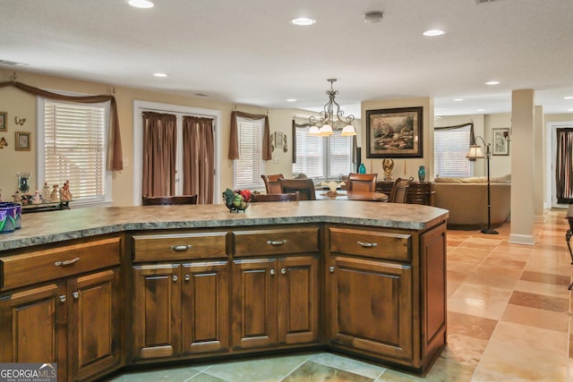 kitchen featuring kitchen peninsula, a chandelier, and pendant lighting