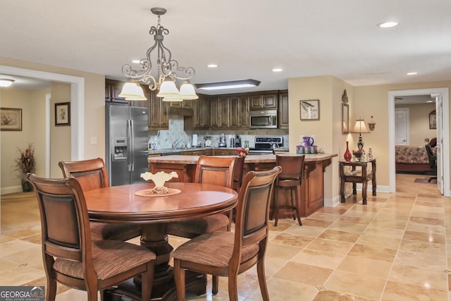 dining space with sink and a notable chandelier