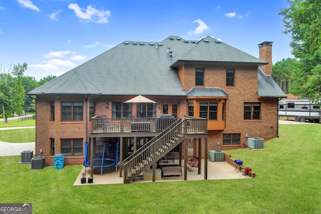 rear view of house with a lawn, central air condition unit, a patio area, and a wooden deck